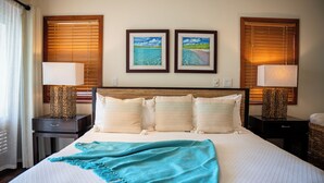 A hotel room with a large bed, two nightstands, a wooden headboard, and two framed pictures on the wall.