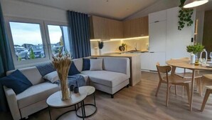 Un saló modern amb un sofà, una taula de dinar i una zona de cuina.