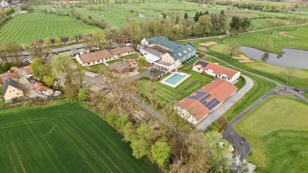 An aerial view of a golf course with a clubhouse, a swimming pool, and surrounding green fields. - 2 bedroom nice home in Rotthalmünster (Rotthalmünster)