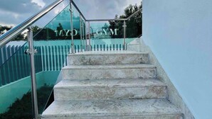 Une série de marches en pierre menant à une porte en verre sur laquelle on peut lire les mots « MYO GYM ».
