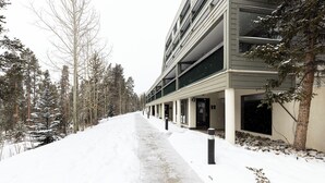 A snow-covered pathway leading to a modern building with multiple floors and balconies. - Sj2503-3 (Keystone)
