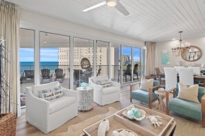 A spacious living area with a balcony, white furniture, and a view of the cityscape. - Barefeet Retreat Renovated Unit in Beachfront Bldg Tides 708 (Miramar Beach)