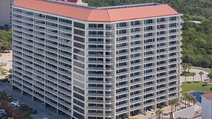 A high-rise hotel with multiple balconies, a swimming pool, and a parking area. - Posh Beachfront Penthouse With Spectacular Gulf Views Tops'l Tides 1507 (Miramar Beach)