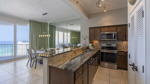 A modern kitchen with a large island, stainless steel appliances, and a view to the outside. - Posh Beachfront Penthouse With Spectacular Gulf Views Tops'l Tides 1507 (Miramar Beach)