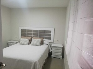 1 dormitorio y tabla de planchar con plancha