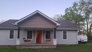 A two-story house with a front porch, a red door, and a stone foundation. - Beautiful Home in Gallatin (Gallatin)