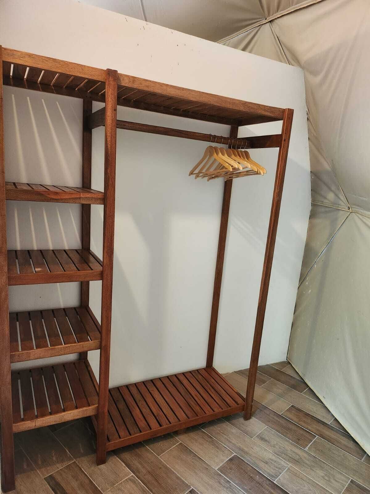 Un armario de madera con varios estantes y una barra para colgar.