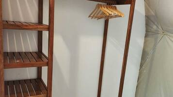 Un armario de madera con varios estantes y una barra para colgar.