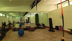 A gym with exercise equipment, a mirror, and a punching bag.
