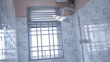 Habitación básica, vista al jardín | Baño | Regadera, regadera tipo lluvia, pantuflas, toallas