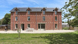 A red brick building with a symmetrical facade, multiple windows, and a central entrance.