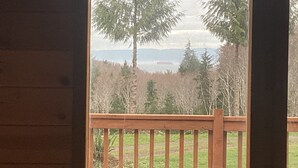 Una terraza de madera con vistas a un bosque y montañas.
