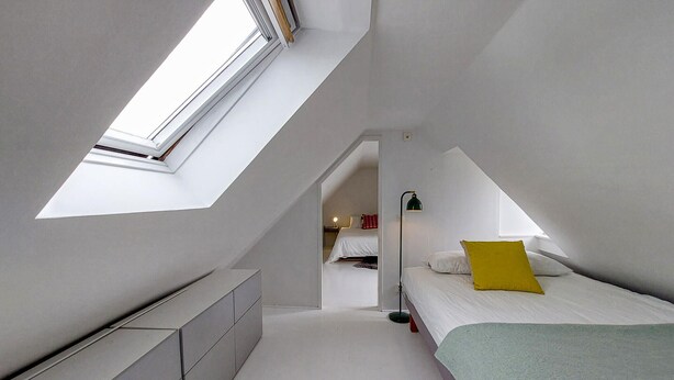 A bedroom with a skylight, a bed with pillows, a bedside table, and a dresser. - Awesome home in Limhamn with kitchen (Limhamn)