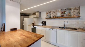 A modern kitchen with white cabinetry, a wooden countertop, a built-in oven, and a stainless steel sink. - Awesome home in Limhamn with kitchen (Limhamn)