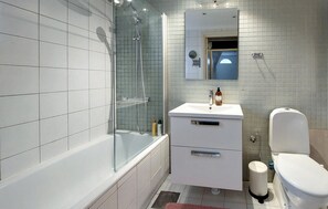 A modern bathroom with a glass-enclosed shower, a white sink with a mirror above, and a toilet. - Awesome home in Limhamn with kitchen (Limhamn)