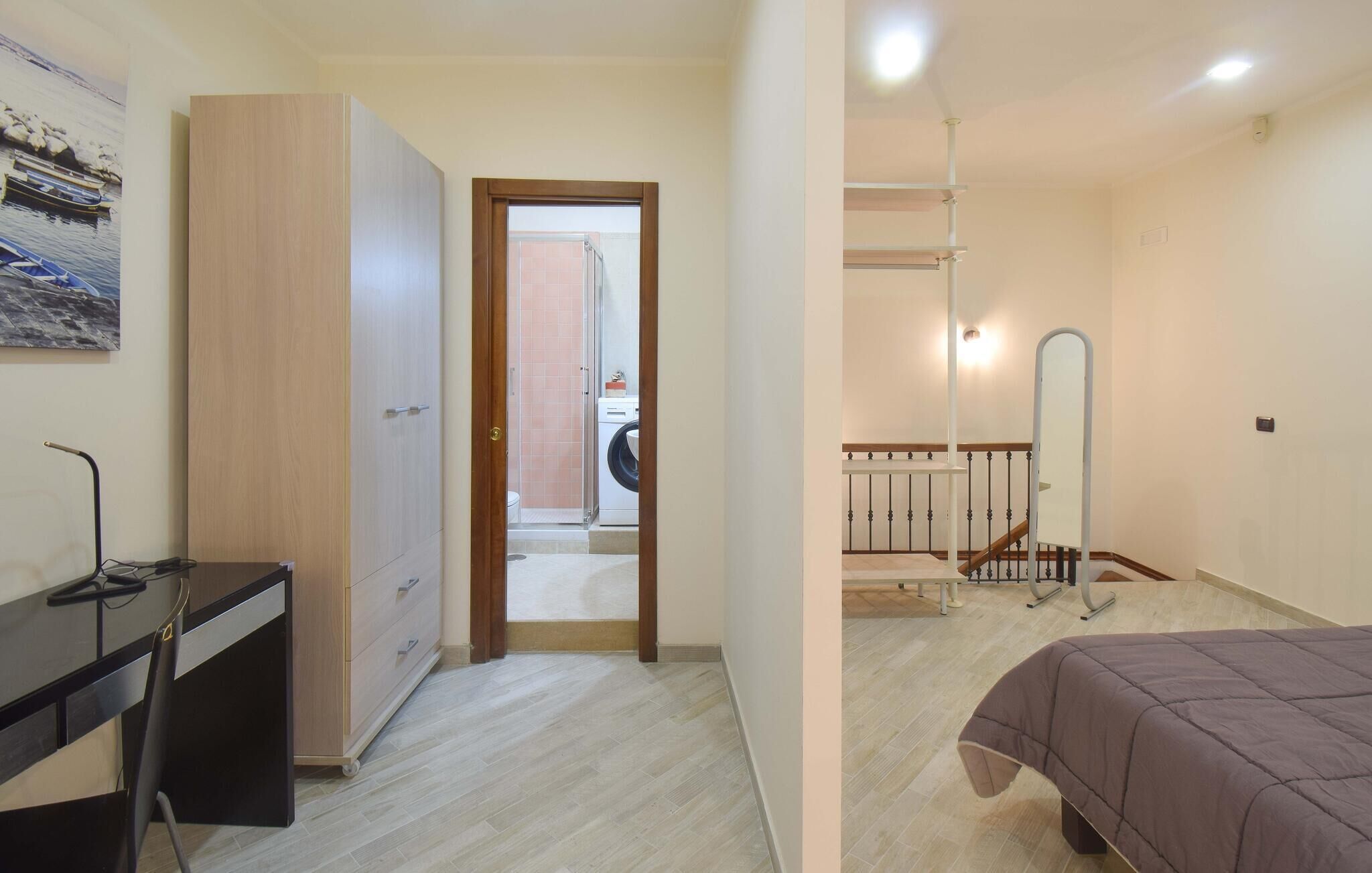 Een slaapkamer met een bed, een bureau en een kledingkast.