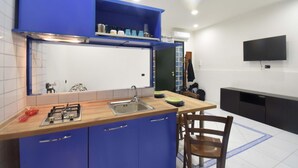 Eine moderne Küche mit blauen Schränken, einer Holzarbeitsplatte, einem Gasherd und einer integrierten Spüle.