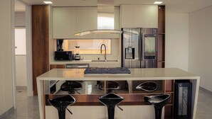 A modern kitchen with a central island, stainless steel appliances, and a minimalist design.