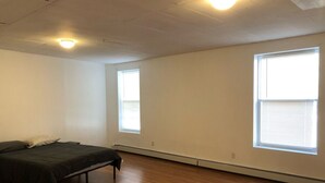 A room with a bed, a window, and a radiator.