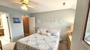 A bedroom with a bed, a ceiling fan, a door, and decorative wall art. - Lovely Mallard Lakes townhome, minutes from Fenwick and OC beaches. (Selbyville)