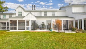 A modern two-story house with a covered patio, large windows, and a well-maintained lawn. - Lovely Mallard Lakes townhome, minutes from Fenwick and OC beaches. (Selbyville)