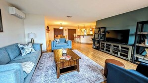 A living room with a sofa, coffee table, and TV stand.