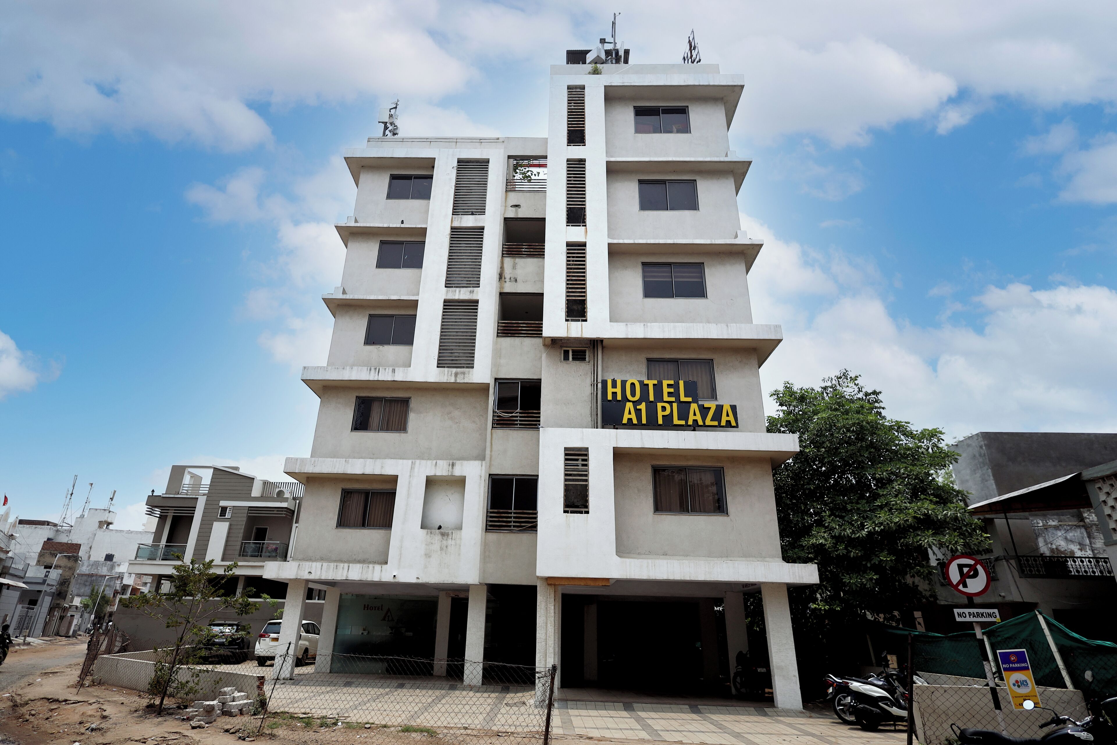 Un hôtel à plusieurs étages, doté de balcons et d’une enseigne indiquant « HÔTEL A1 PLAZA ».