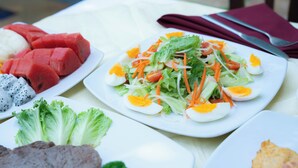 Una mesa con diversos platos, incluyendo sandía, huevos y una ensalada.
