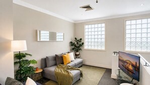 A living room with a sofa, a television, and a large window. - Great apartment in the City / Broadway-Chippendale, Sydney (Chippendale)