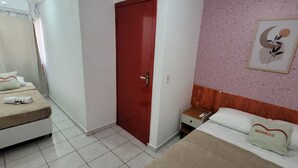 A hotel room with a bed, a nightstand, a red door, and a wall with a framed picture. - Matianellu SP (São Paulo)