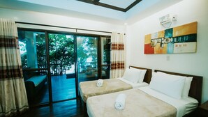 A hotel room with two beds, a large sliding glass door leading to a balcony, and a colorful abstract painting on the wall. - El Nido Water Front (El Nido)