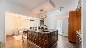 Une cuisine moderne dotée d’un grand îlot central, de meubles en bois et d’un four encastré.
