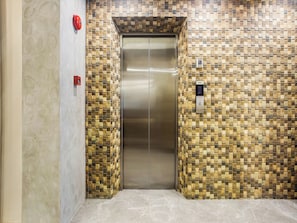 An elevator with a patterned wall and a metallic door. - Airo Hotel-Manila (Manila)
