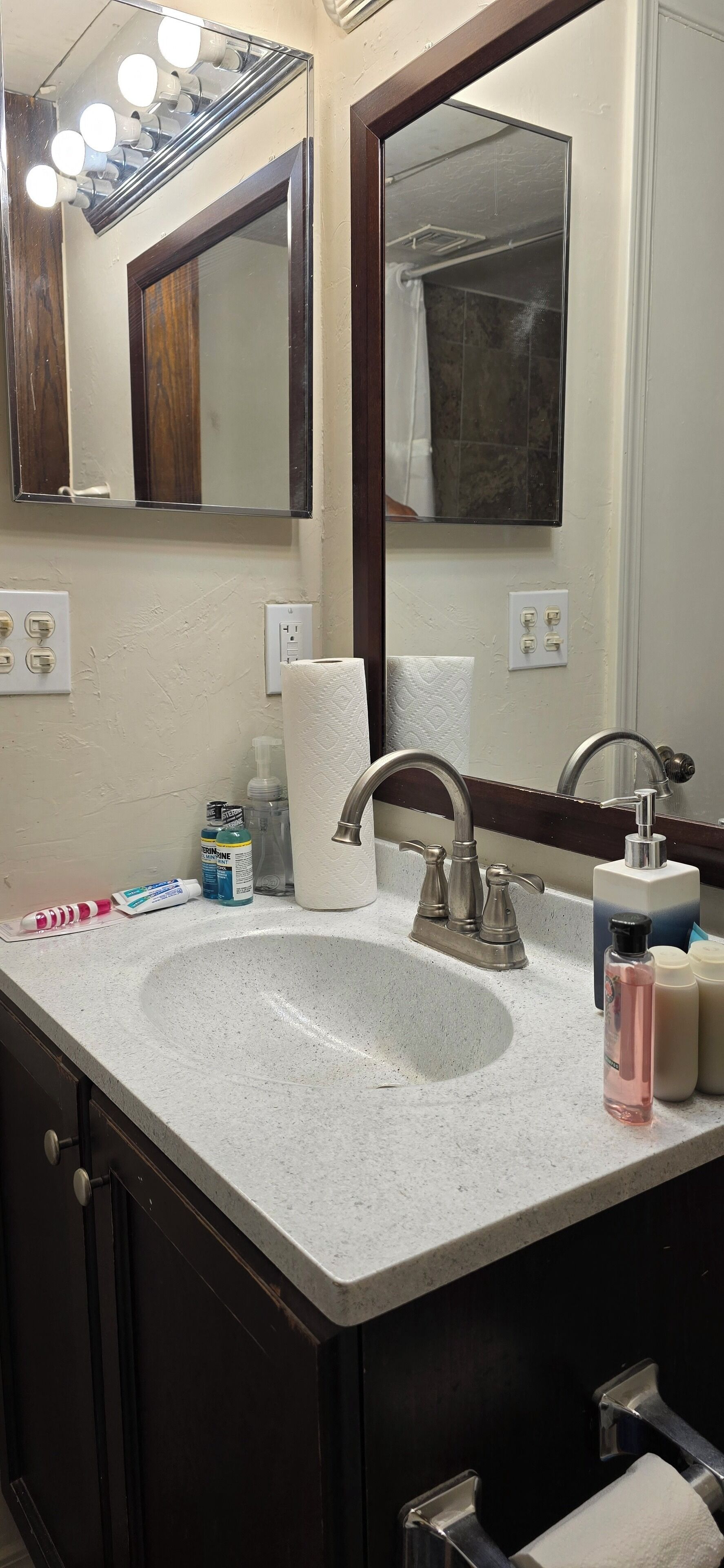 Une salle de bain avec un lavabo, un miroir et des luminaires.