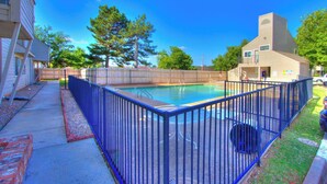 A swimming pool with a blue fence, surrounded by a wooden deck and a building with a sloped roof. - Cozy Updated Cove of Heaven, 5 mins from Lake Hefner and mall. Centrally located (Oklahoma City)