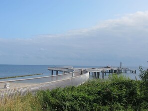Un muelle que se adentra en el agua con un paseo techado y una plataforma de observación.