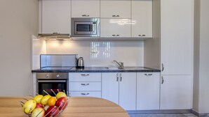 A modern kitchen with white cabinets, a stainless steel microwave, and a built-in oven. - Apartment Palms by Interhome (Opatija/Pobri)