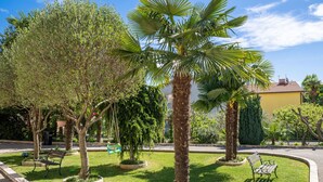 A well-maintained garden with palm trees, benches, and a paved walkway. - Apartment Palms by Interhome (Opatija/Pobri)