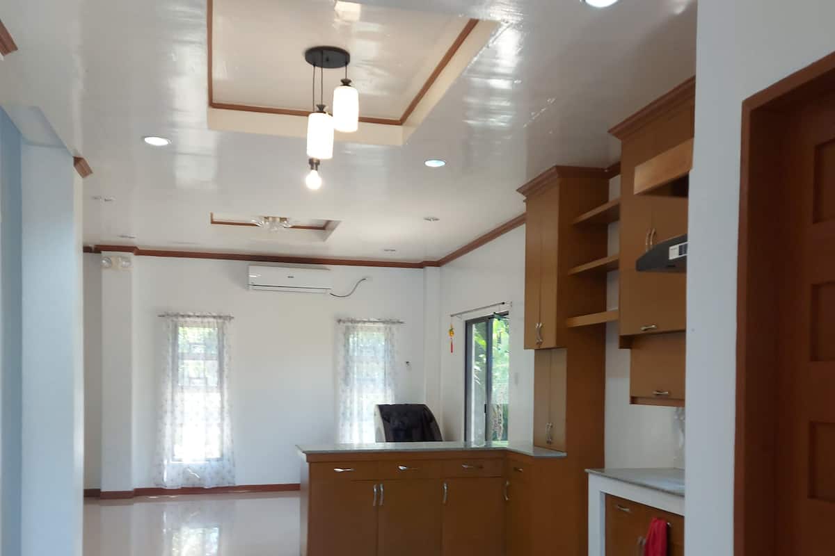 A spacious room with a polished floor, wooden cabinets, and a ceiling with recessed lighting.
