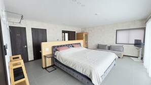 A modern bedroom with a large bed, a bedside table, a wardrobe, and a TV. - Ocean view retreat! Luxury villa with sauna (本部町)