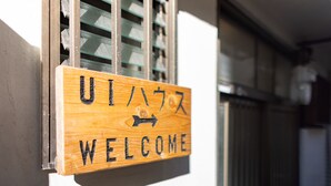 A wooden welcome sign with Japanese characters and an arrow pointing to the right. - UI HOUSE@Minamihorie (1 building rental / 2 stations 4 min. to Namba / walking distance to Kyocera Dome) (大阪市)