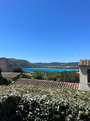 Blick auf die Küste mit Häusern mit Terrakotta-Dächern, einem klaren, blauen Himmel und einem fernen türkisfarbenen Meer.