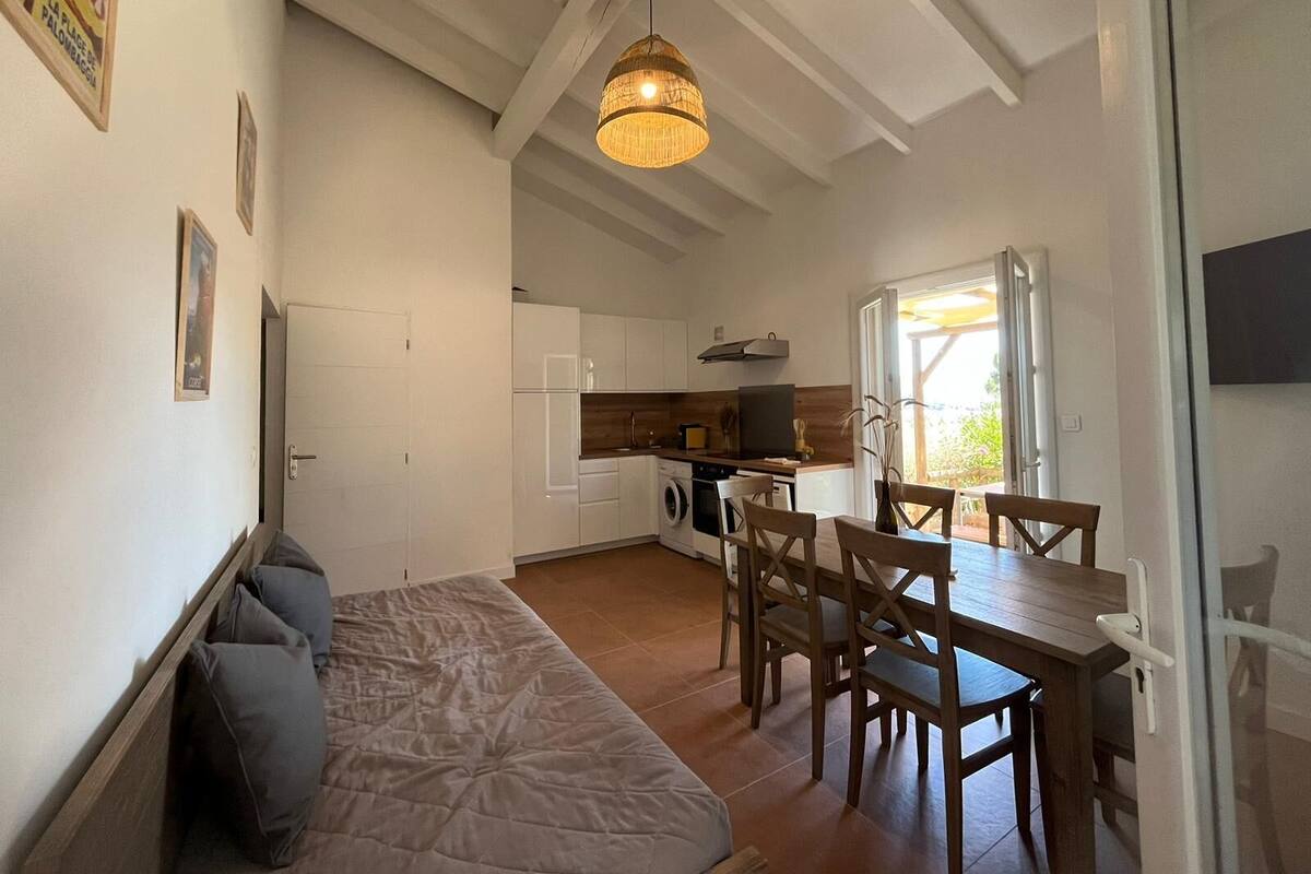 Een knus woongedeelte met een kitchenette, een eethoek en een bank.