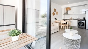 Eine moderne Küche mit Deckenventilator, einem Essbereich mit Tisch und Stühlen sowie einem Sofa.