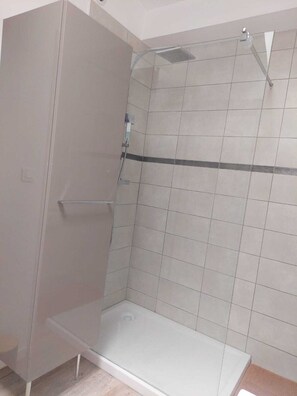 Chuveiro, secador de cabelo, toalhas de banho, papel higiênico