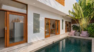 Una piscina al aire libre, sombrillas, sillones reclinables de piscina