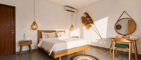 A bedroom with a wooden bed, bedside tables, a round mirror, and a hanging feather decoration.