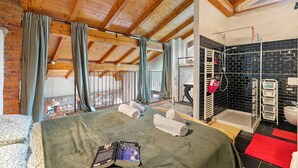 A room with a wooden ceiling, a bed with towels, a book, a balcony with a view, and a bathroom with a shower and a toilet. - La Maison Du Lac - 50 Meters From Lake , Private Parking&bbq (Monvalle)