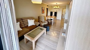 A modern living room with a sofa, coffee table, and dining area. - Beautiful and comfortable apartment in Denia, Costa Blanca, Spain  with communal pool for 4 persons (Denia)