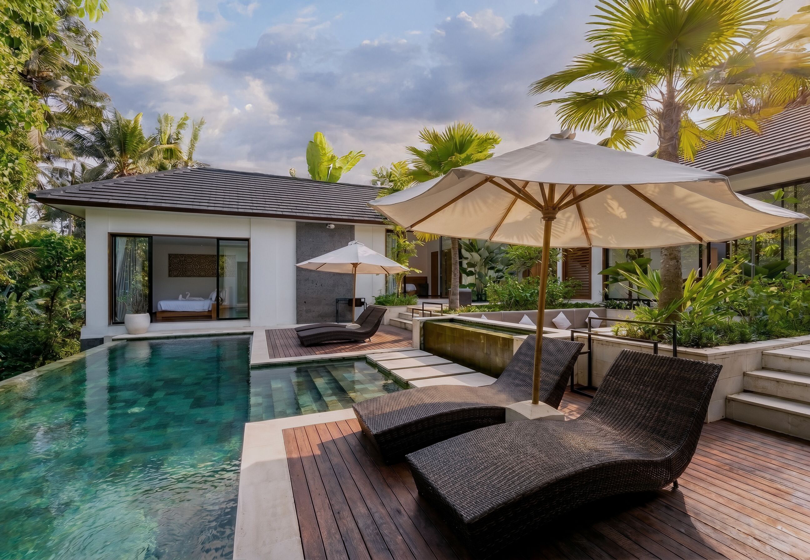 Ein modernes Haus mit Schwimmbad, Liegestühlen und einem großen Sonnenschirm.